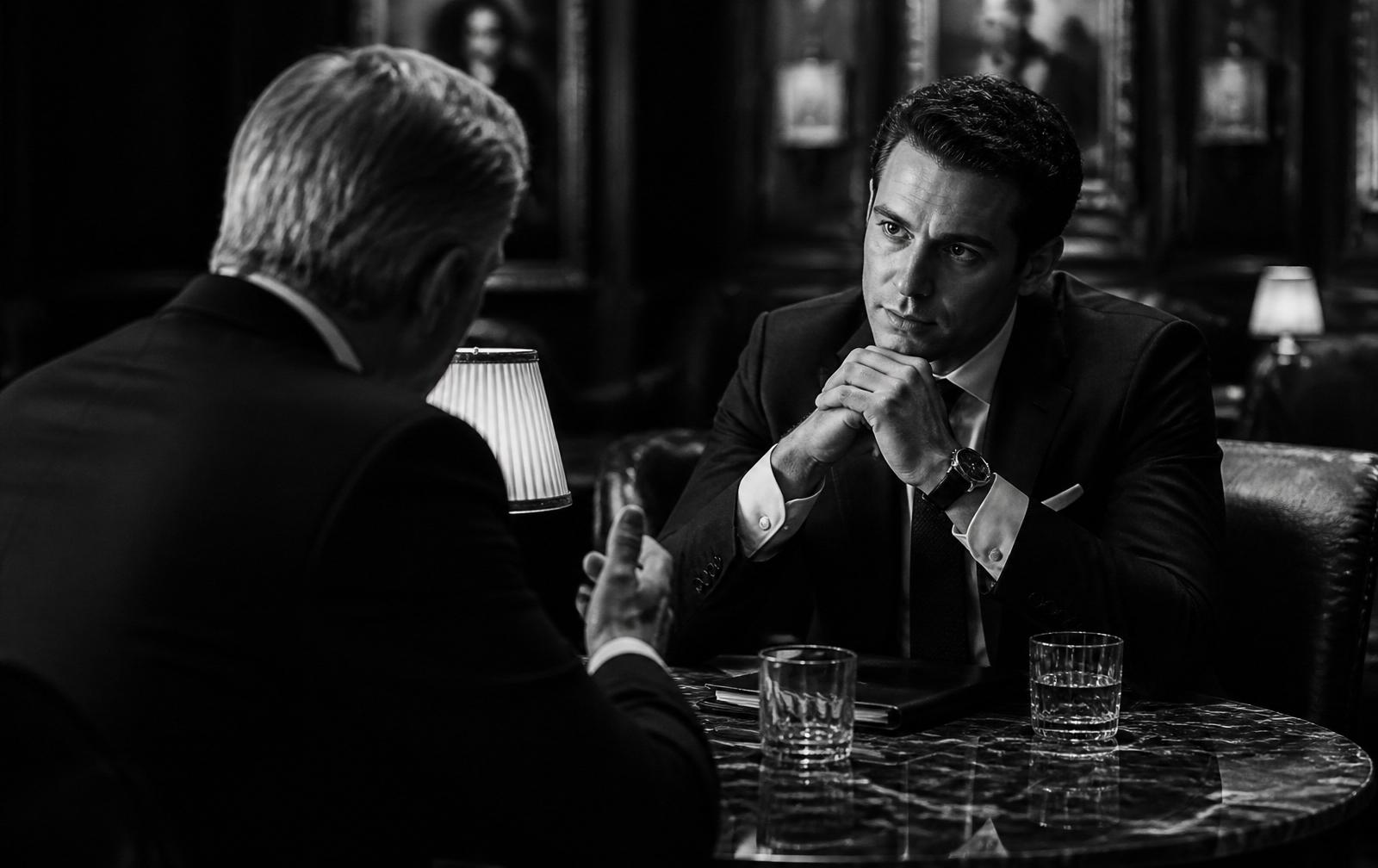 Two executives in conversation across a marble table
